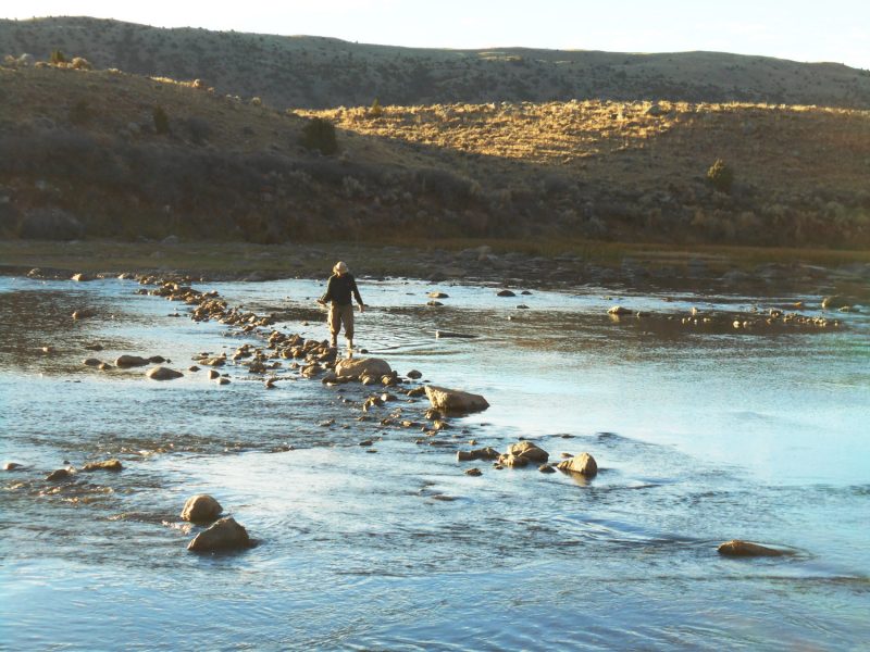 Crewmember standing in shallow section of river.