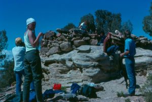 Crewmembers gathered at large rock feature.
