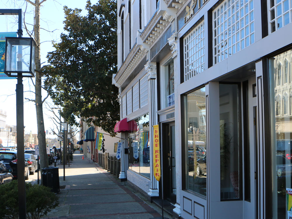 View of business facades from sidewalk in downtown Danville, featuring ornate fenestration and modern 