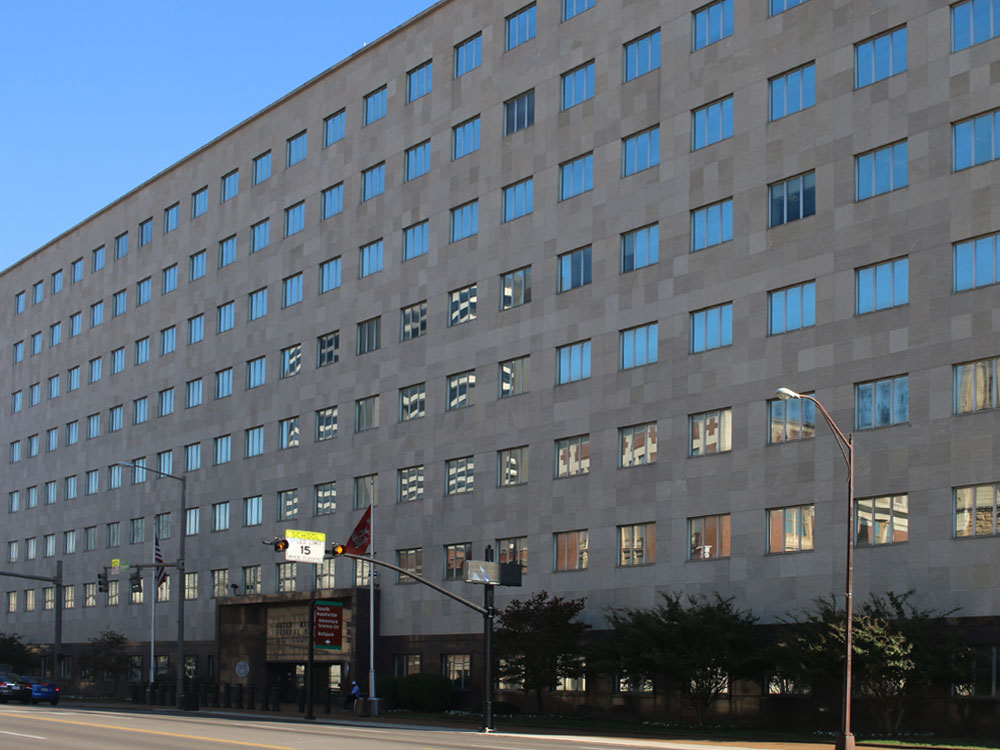 Expansive concrete building with grid of three-pane windows.