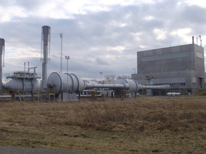 Overview of large equipment/structures with industrial building in background.