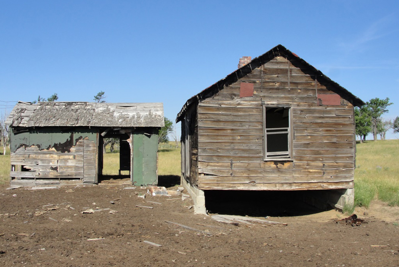 Two abandoned and deteriorated wooden sheds.