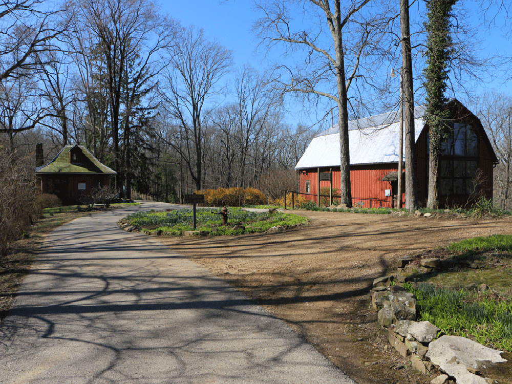 Overview of historic property, including small cabin at left and large barn at right.