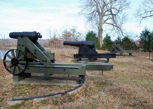 Three historic cannons mounted on concrete bases.