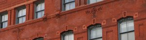 Detail of ornate, red-brick, historic building.