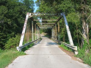 Historic metal bridge shown from roadway entrance.