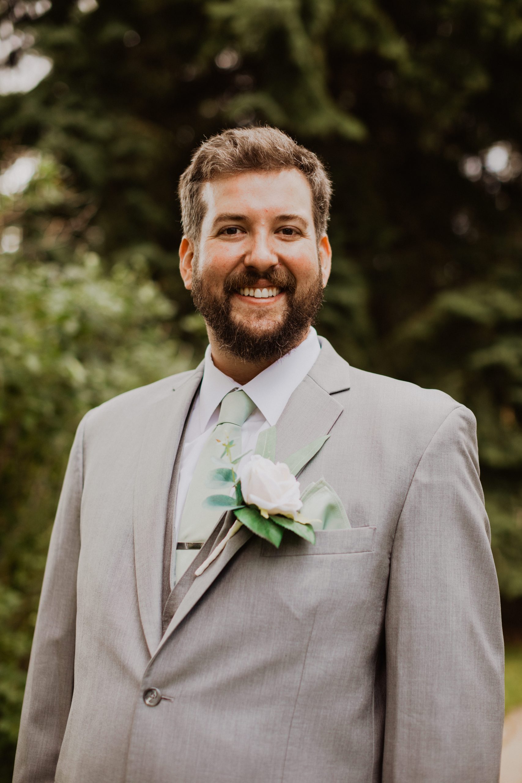 Portrait of Alex wearing grey wedding suit.
